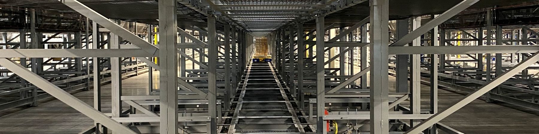 Automatisiertes Lager-Shuttle-Lagersystem mit Stahlregalstruktur und Förderbahnen in einem modernen hochdichten Verteilzentrum für Intralogistik und Materialtransport